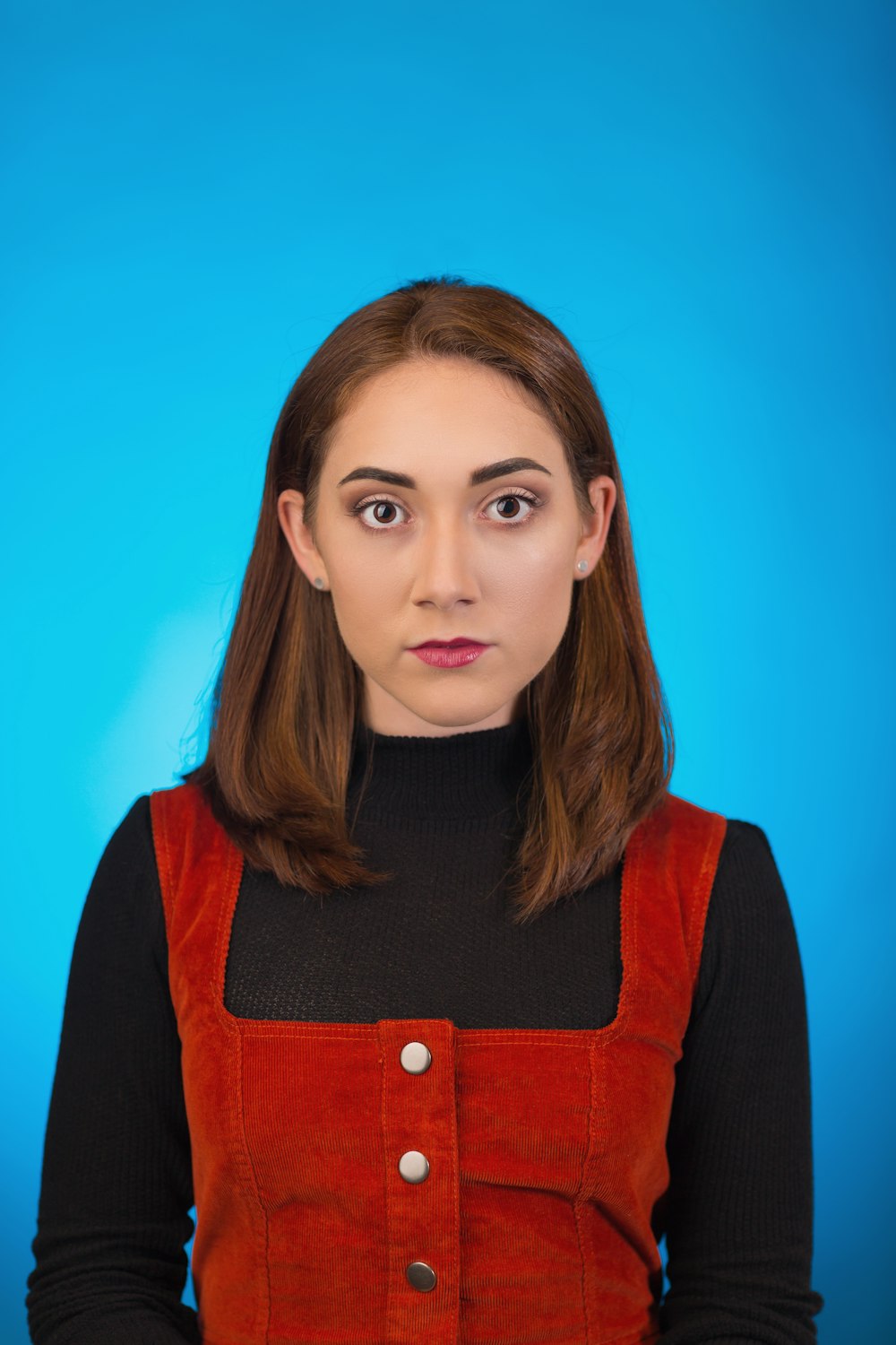 woman wearing red tank top with blue background