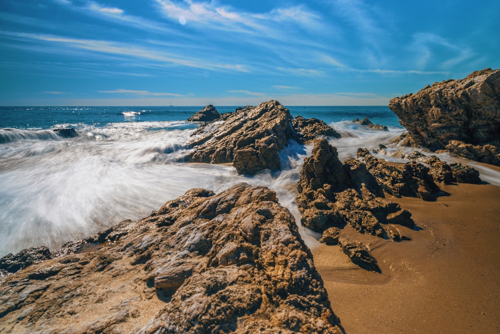 body of water near rock formation during daytime