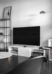 flat screen television on top of white wooden low-line TV stand
