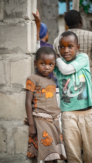 two children learning on wall