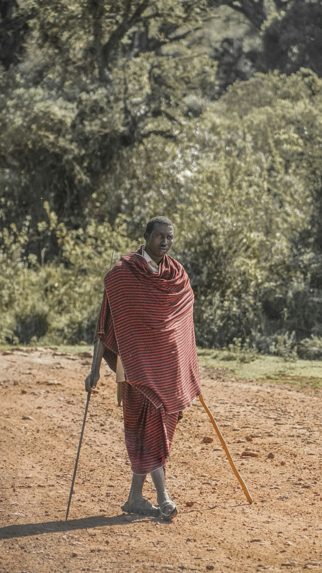 man in red clothe holding brown stick