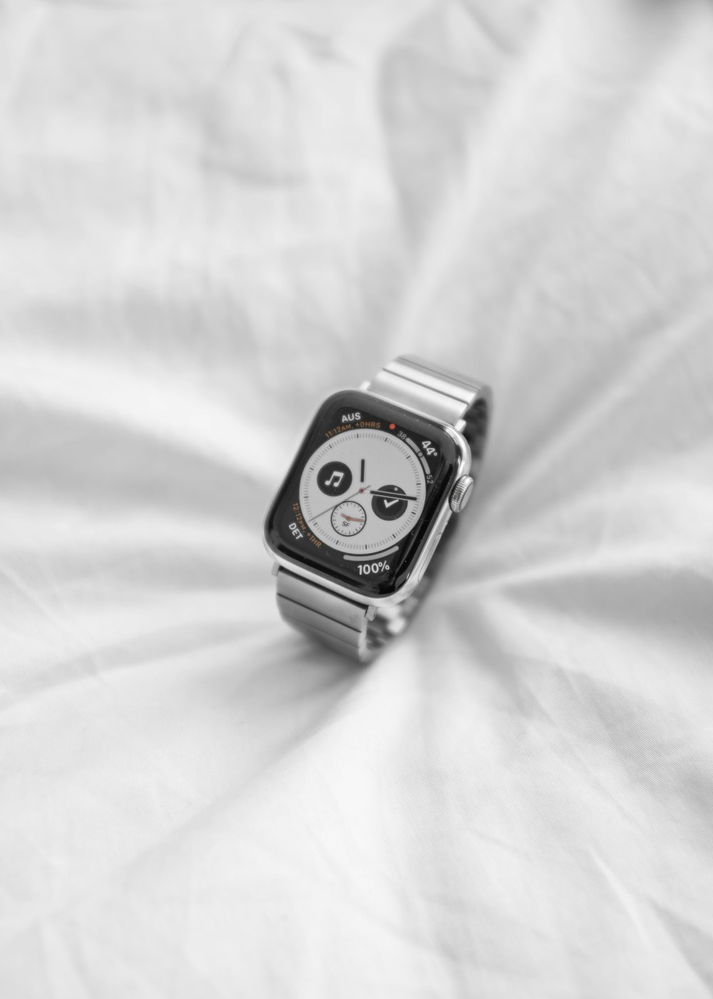 grey and black chronograph watch with band on white textile