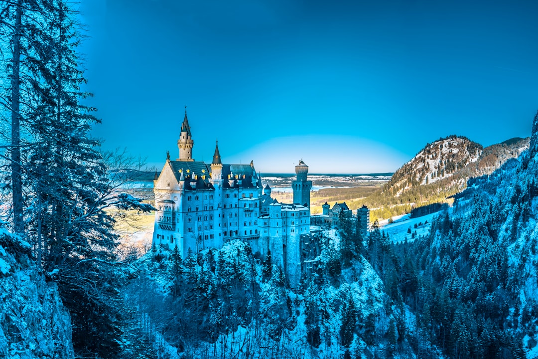 white castle on snow mountain under clear blue sky