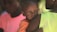 woman carries boy in orange shirt