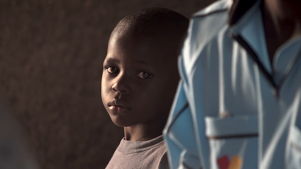 boy standing beside person