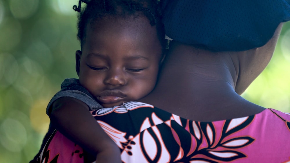 girls sleeping on mother's shoulder