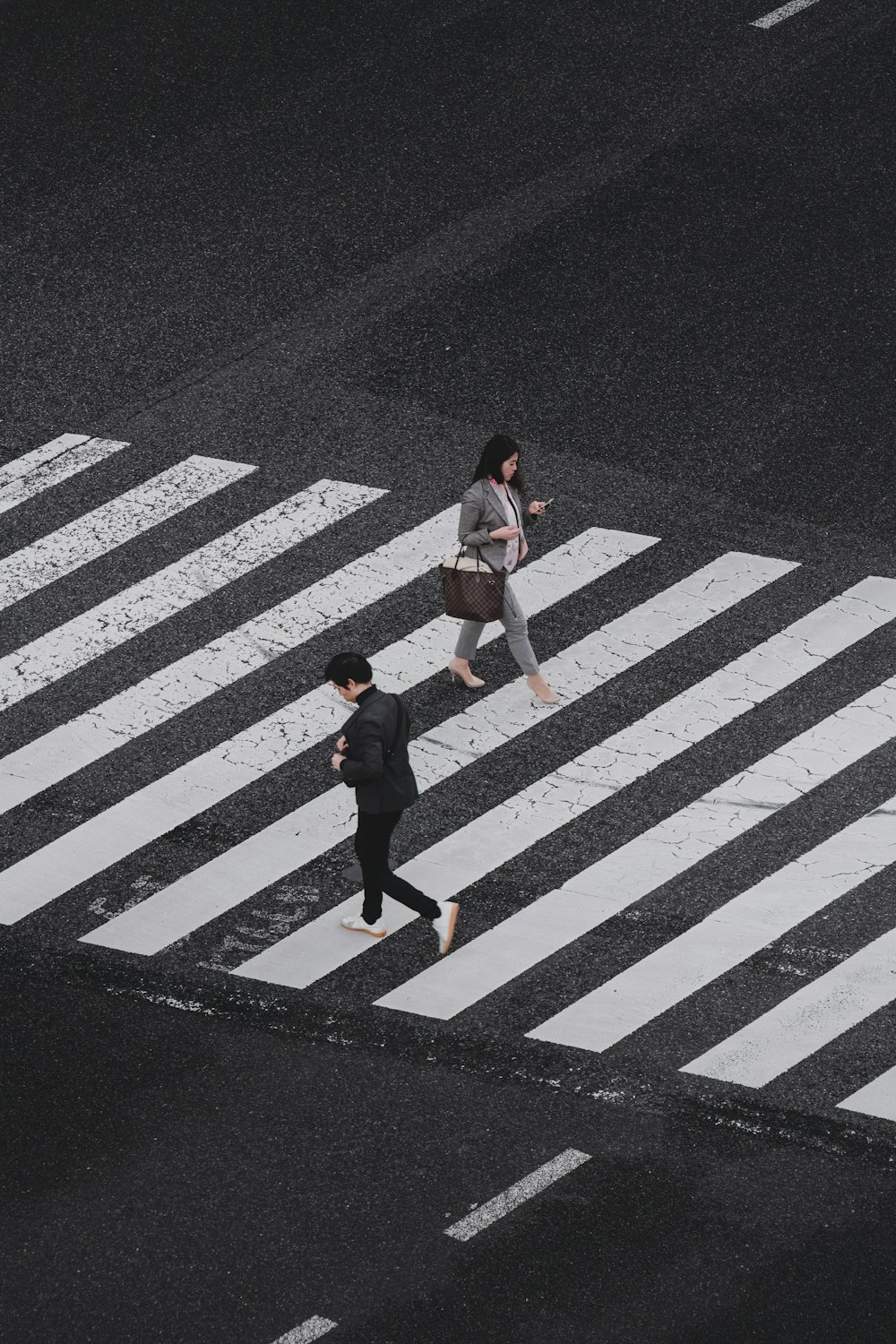 昼間の歩行者専用道路を歩く男女の航空写真