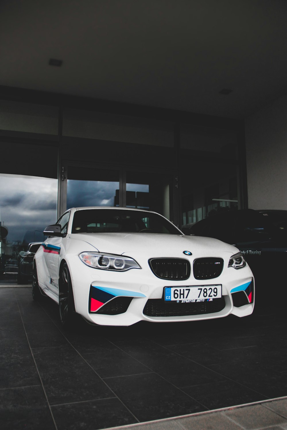 white BMW M-Sport coupe parked inside building