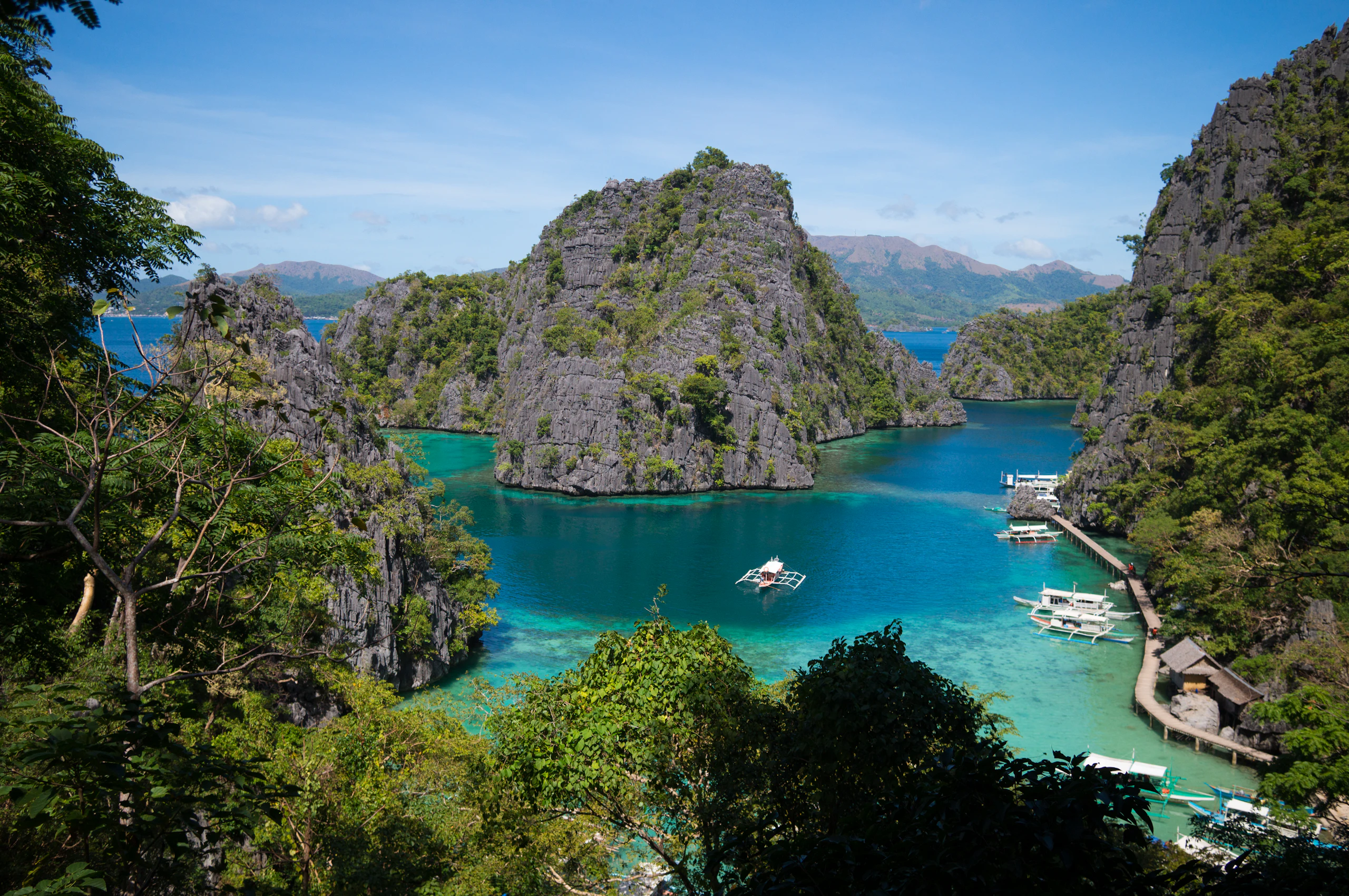 Bangkas moored below limestone rocks, Coron (tagged Coron; no location field)
