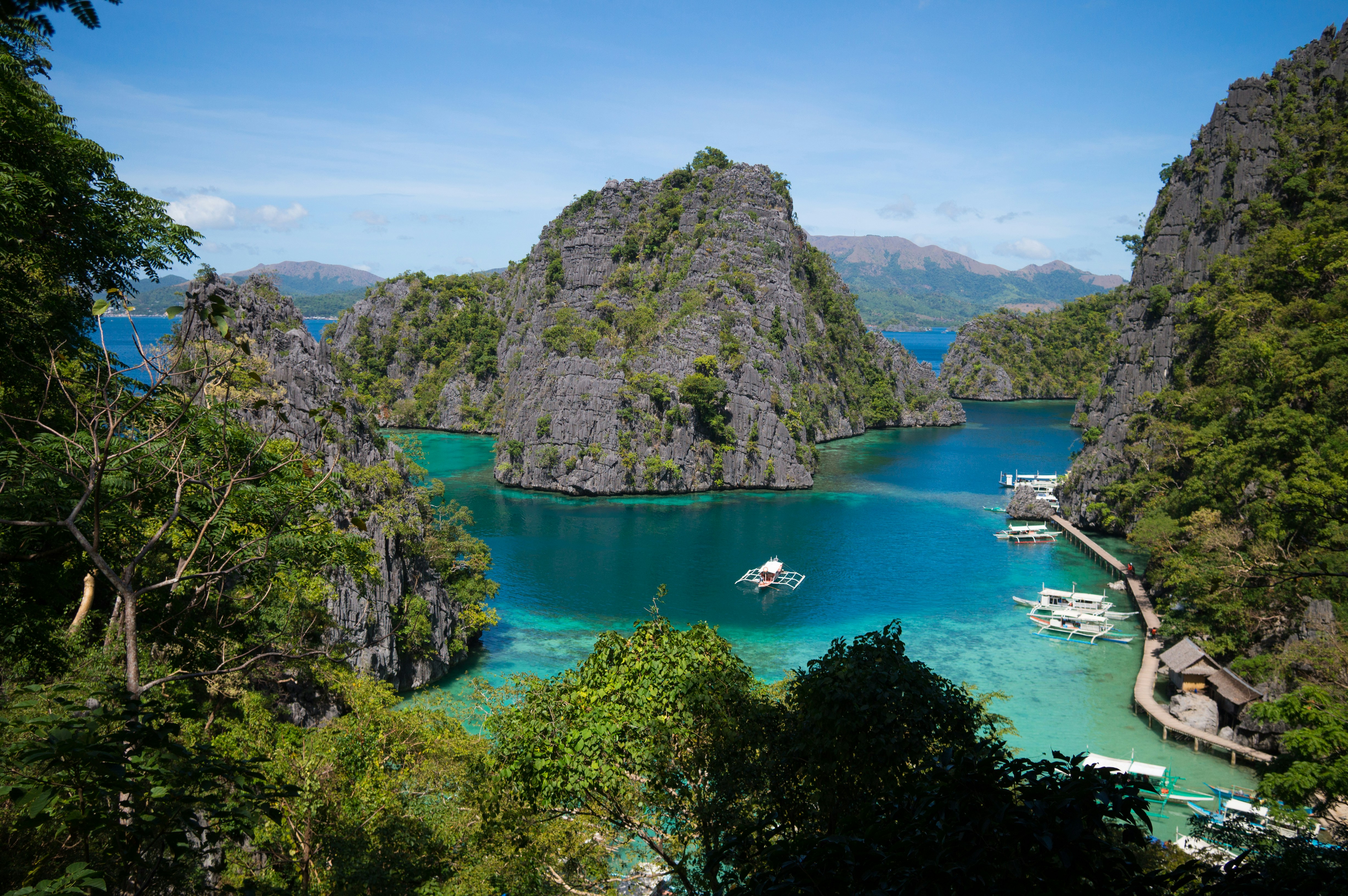 boats on body of water near mountains during daytime