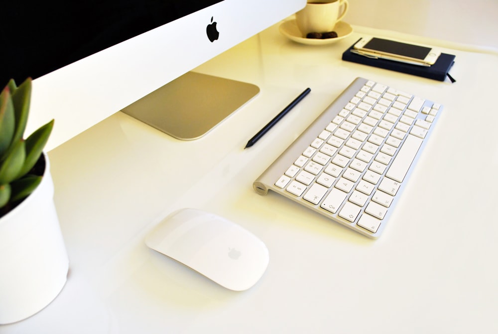 a computer keyboard and mouse on a desk