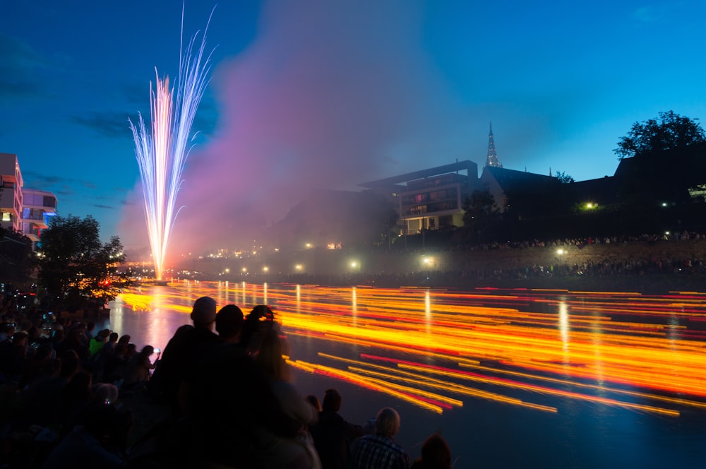 group of people watching fireworks during night time