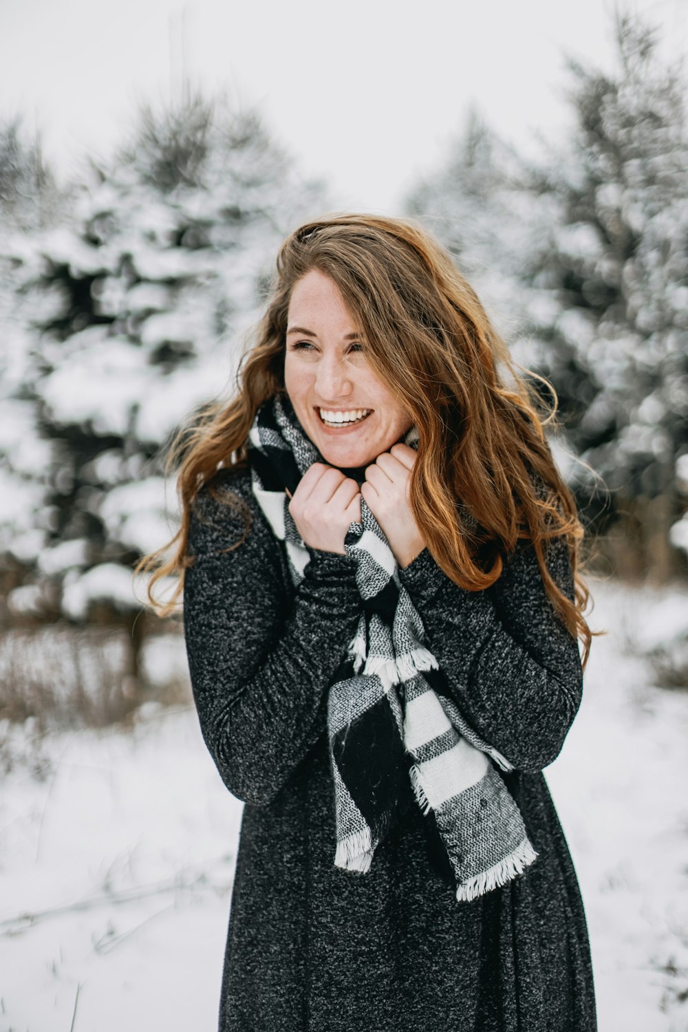 woman wearing coat and grey scarf standing outside during winter