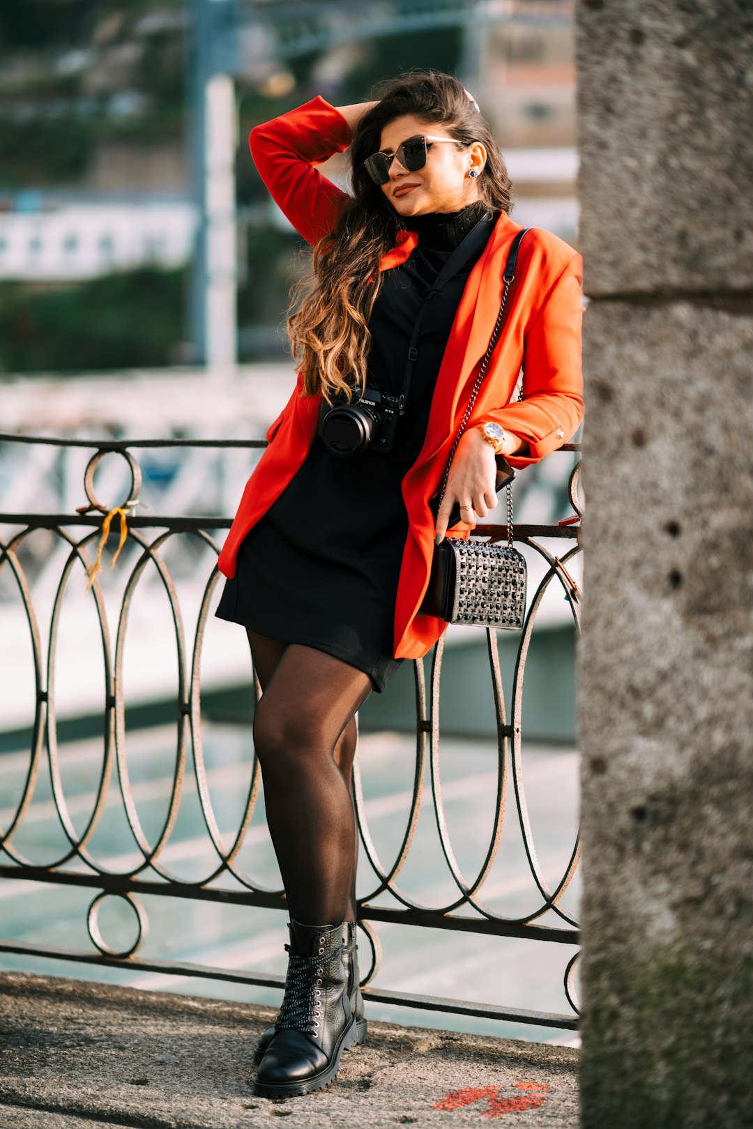 woman in red blazer leaning on gray railings on selective focus photography