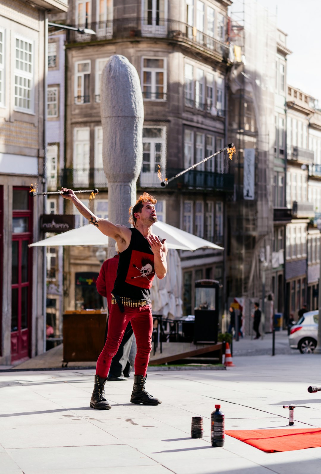 street performer wearing black and red muscle shirt standing on pavement