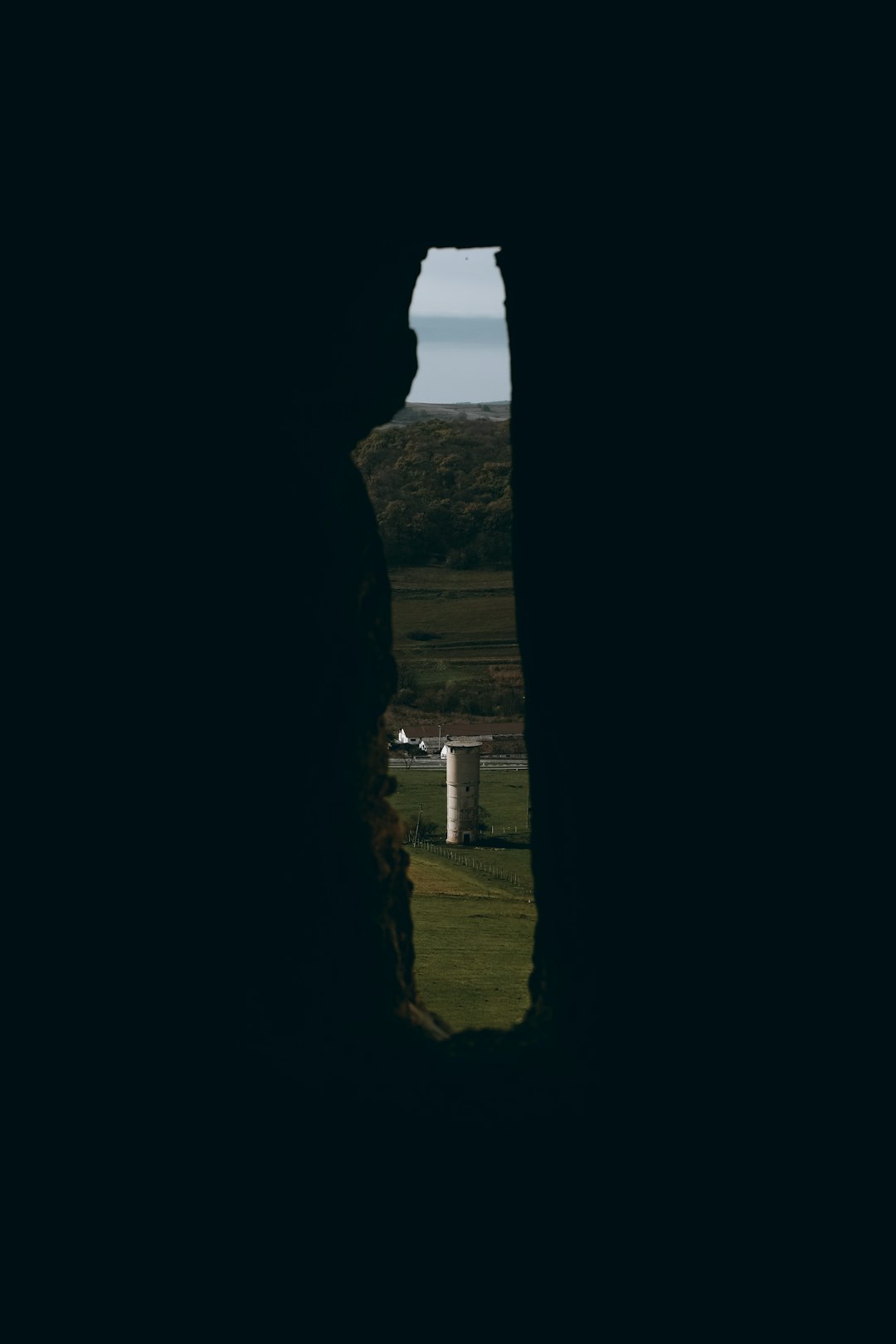 cave hole near green grass field during daytime