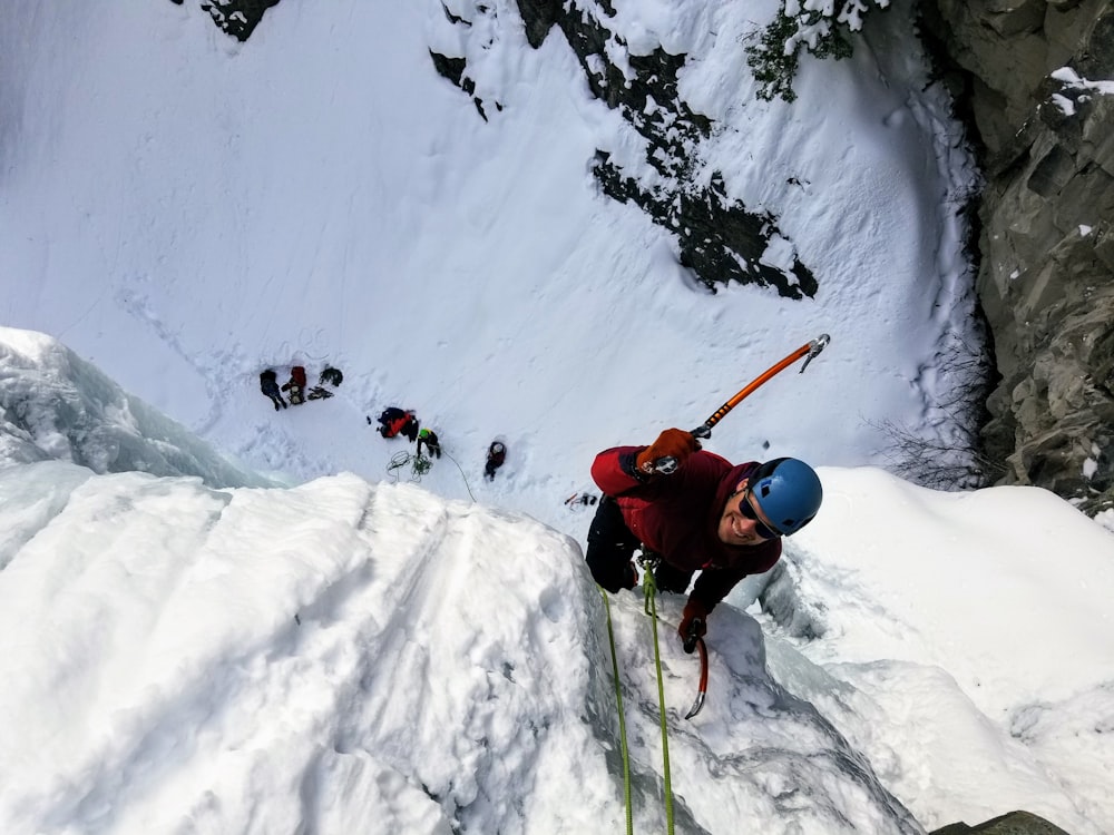 man wearing long-sleeved shirt climbing on mountain