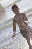Children chasing light beams on a warm, sunlit shoreline.