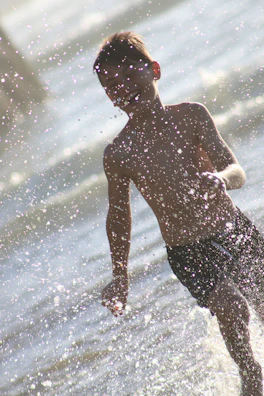 Children chasing light beams on a warm, sunlit shoreline.
