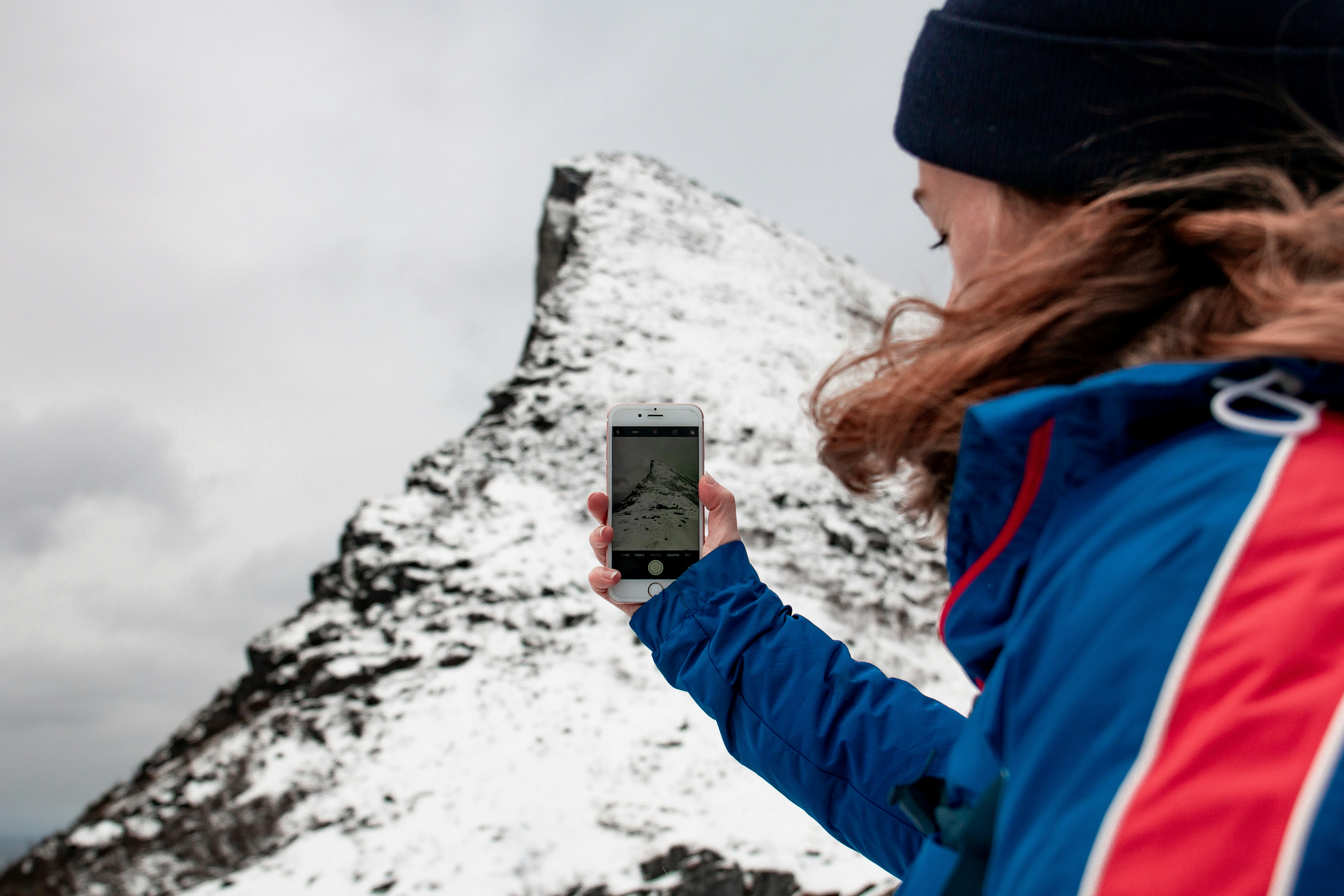 woman taking picture on mountain