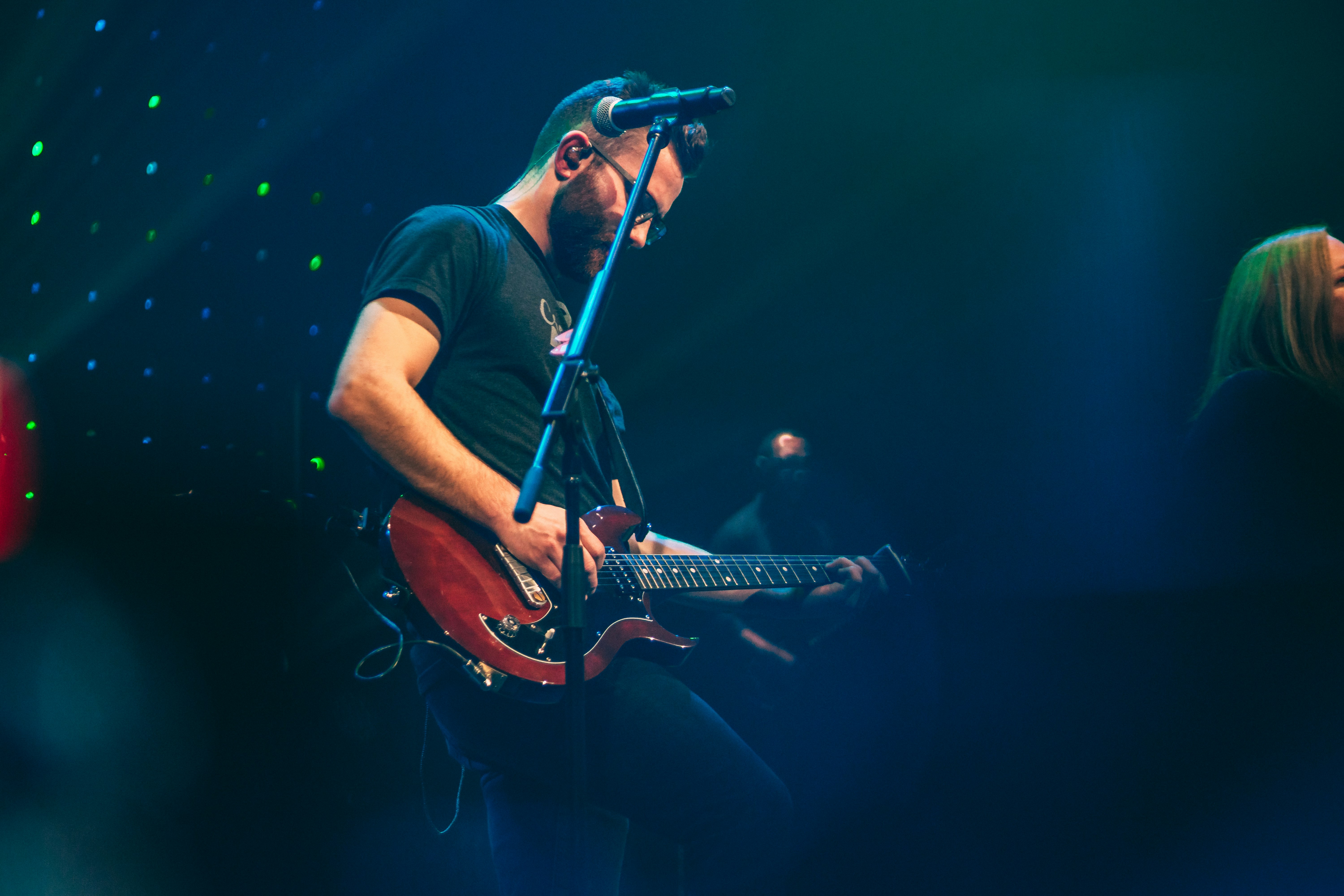 man playing with guitar performing on stage