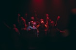 group of person singing on dark ara