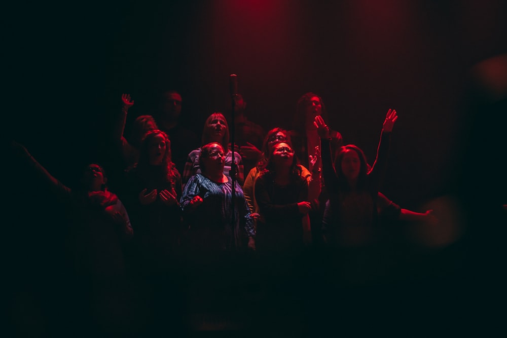 group of person singing on dark ara