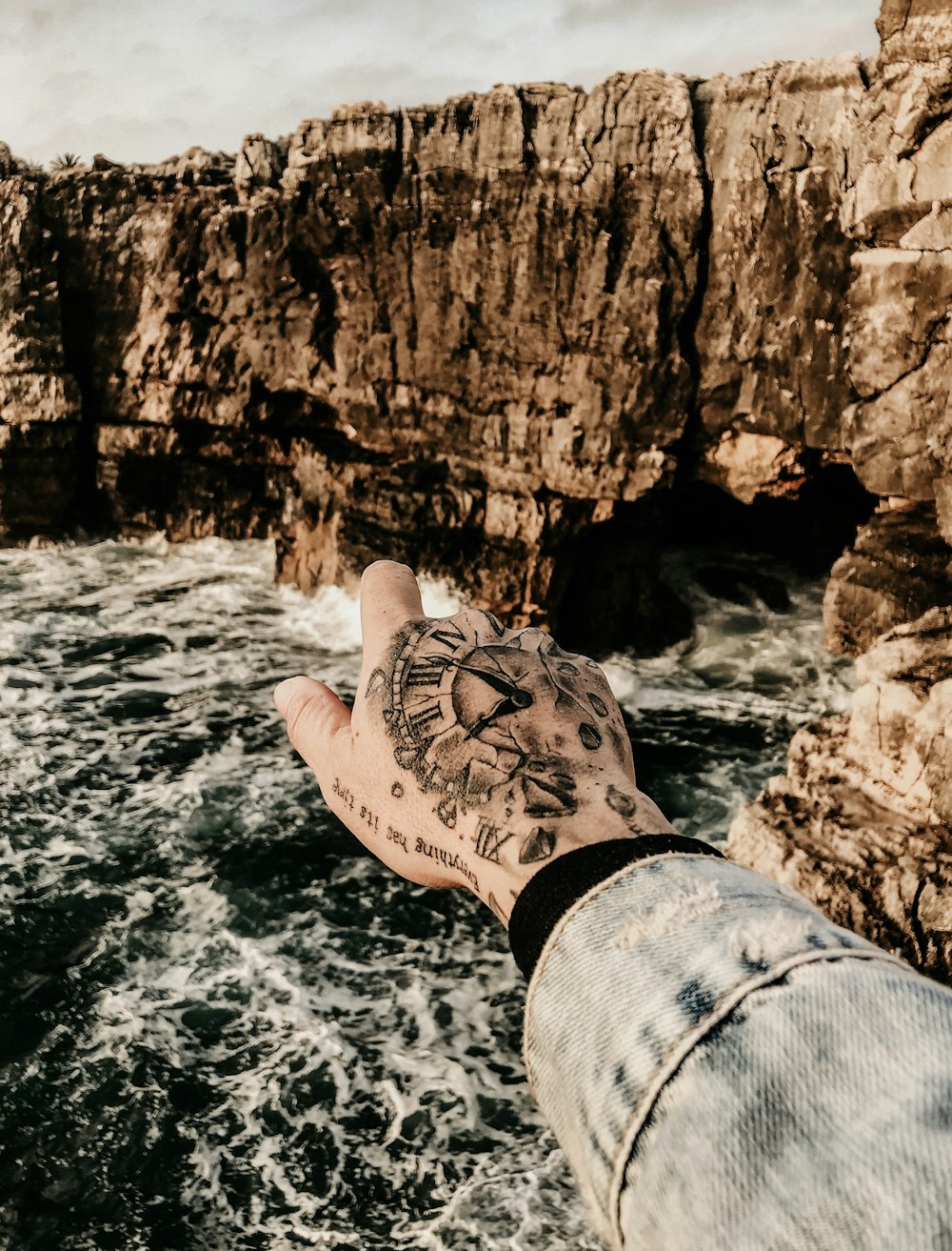 body of water beside rock fragments during daytime