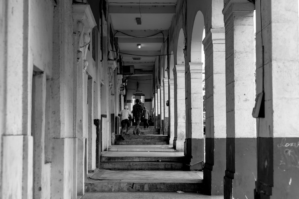 people walking on hallway greyscale photography