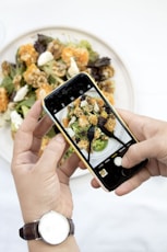 person using iPhone taking picture of food