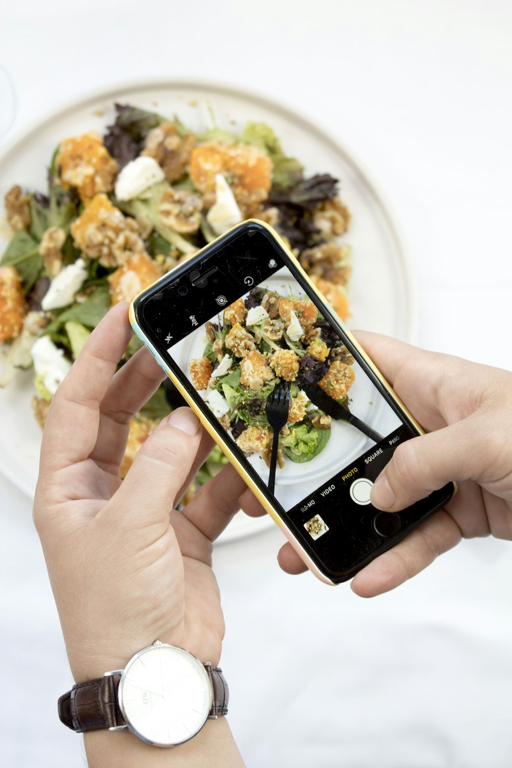 person using iPhone taking picture of food