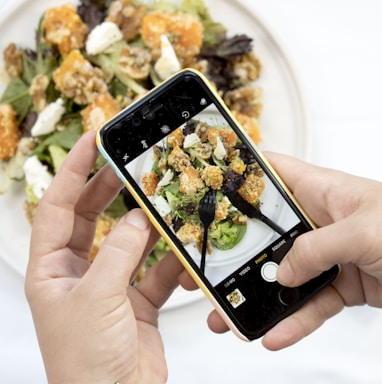 person using iPhone taking picture of food