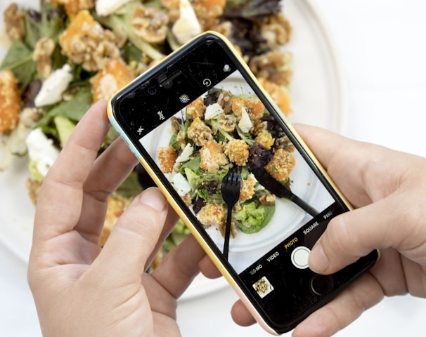 person using iPhone taking picture of food