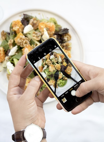 person using iPhone taking picture of food