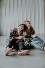 smiling woman and man sitting on floor