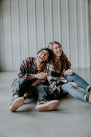 smiling woman and man sitting on floor