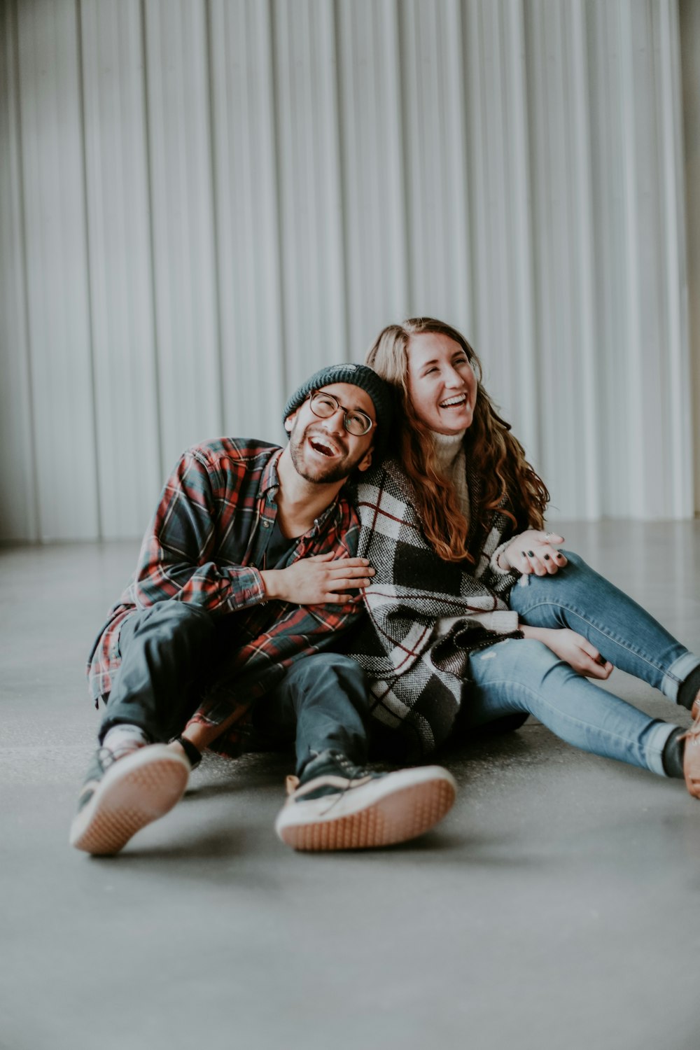 Donna sorridente e uomo che si siedono sul pavimento