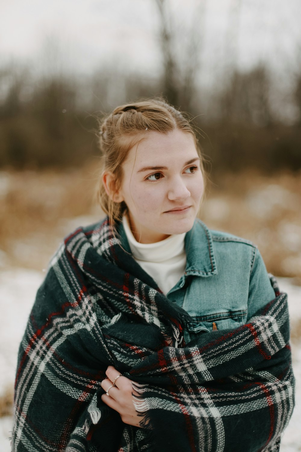 selective focus photography of woman standing near brown trees