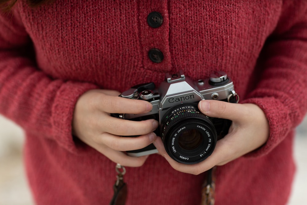 person holding silver Canon camera