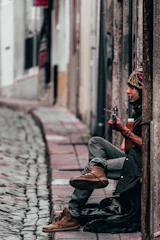 A candid shot of a musician playing guitar on a cozy street corner.