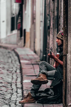 A candid shot of a musician playing guitar on a cozy street corner.