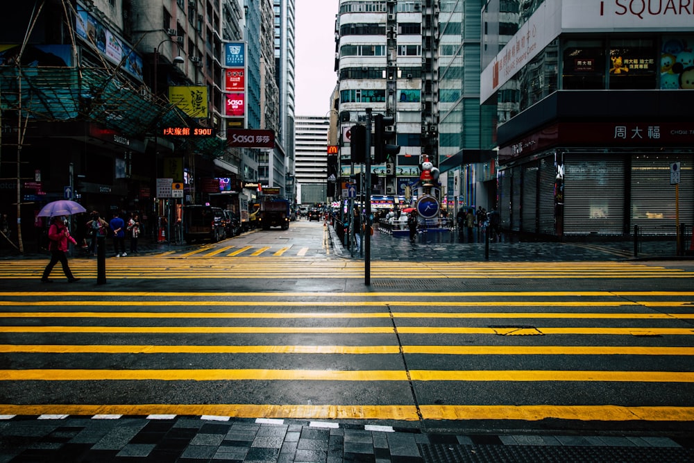 person under purple umbrella walking on street during daytime