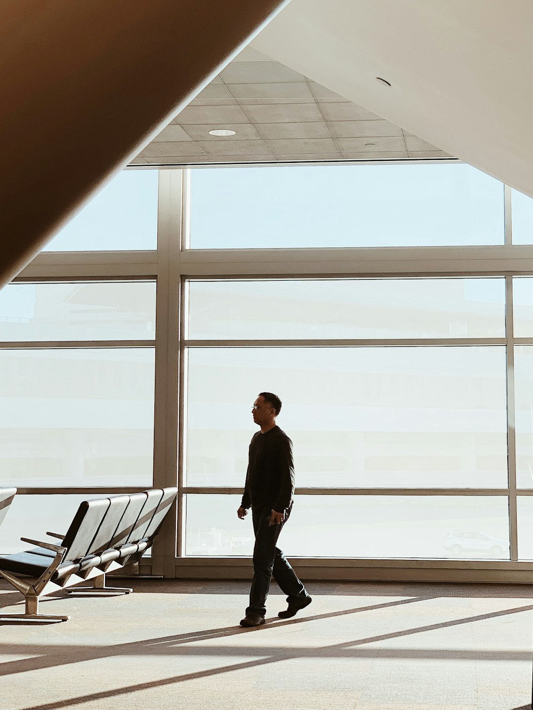 man in black jacket standing near blue gang chair