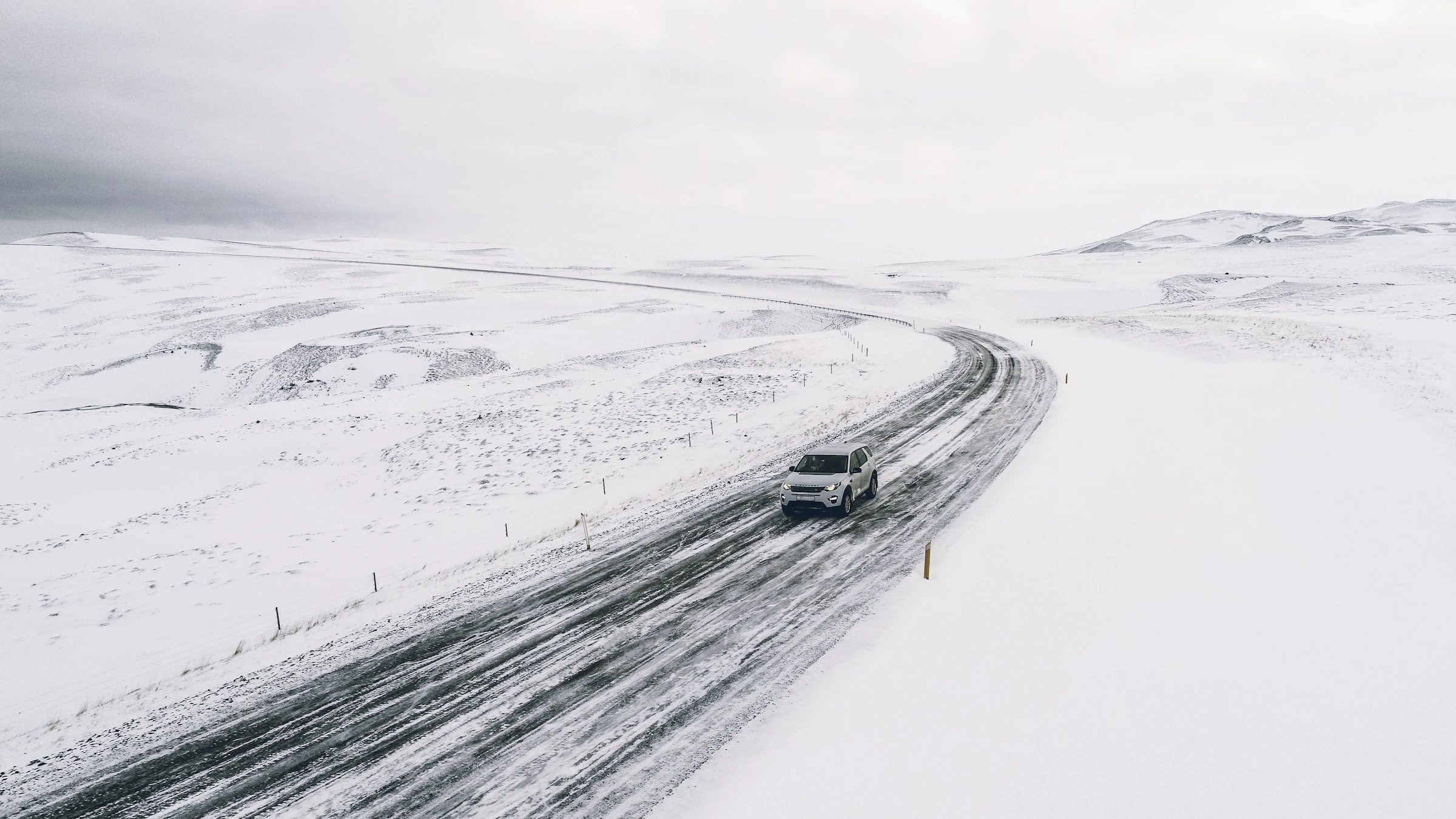 A lone van on an empty mountain road, headed into the hills