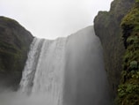 A majestic waterfall surrounded by lush greenery.