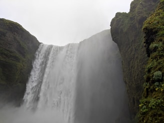 Majestic Iguazu Falls surrounded by lush greenery and mist rising from the cascading water.