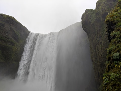 A majestic waterfall surrounded by lush greenery.