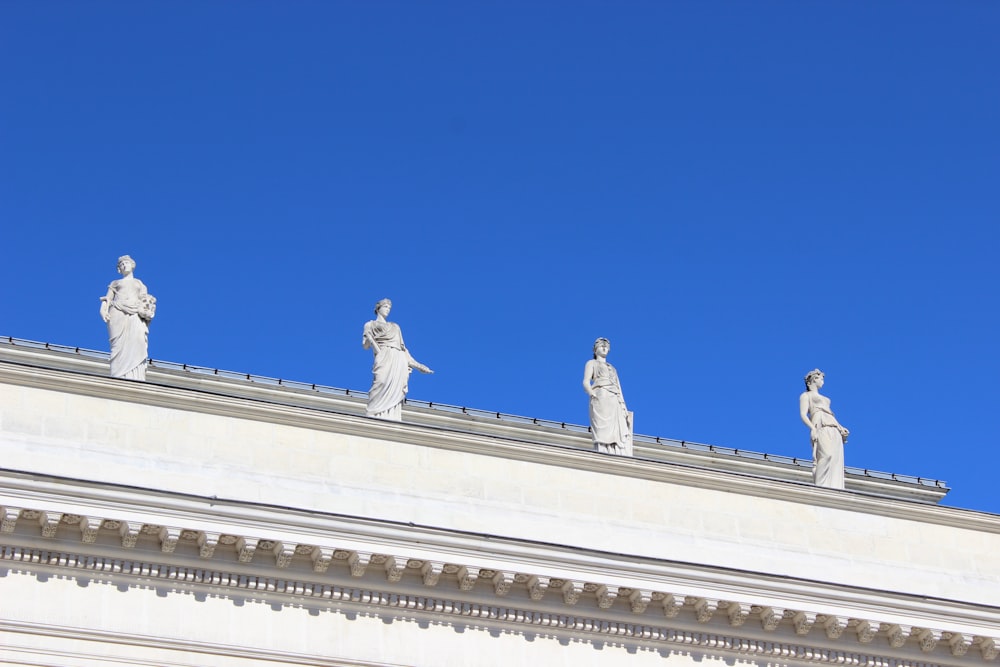 Quatro estátua de concreto branco sob o céu azul claro