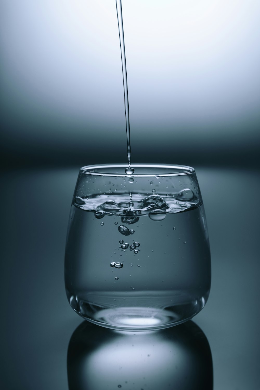 verre à boire clair sur une surface grise