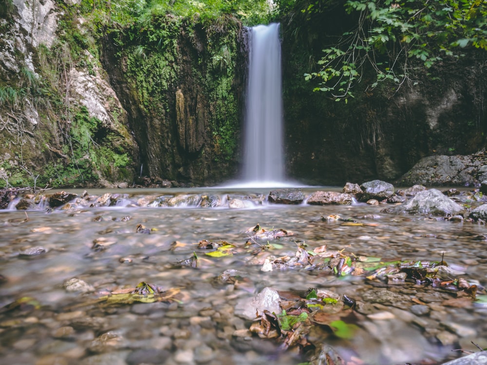 waterfalls beside mountain during daytime